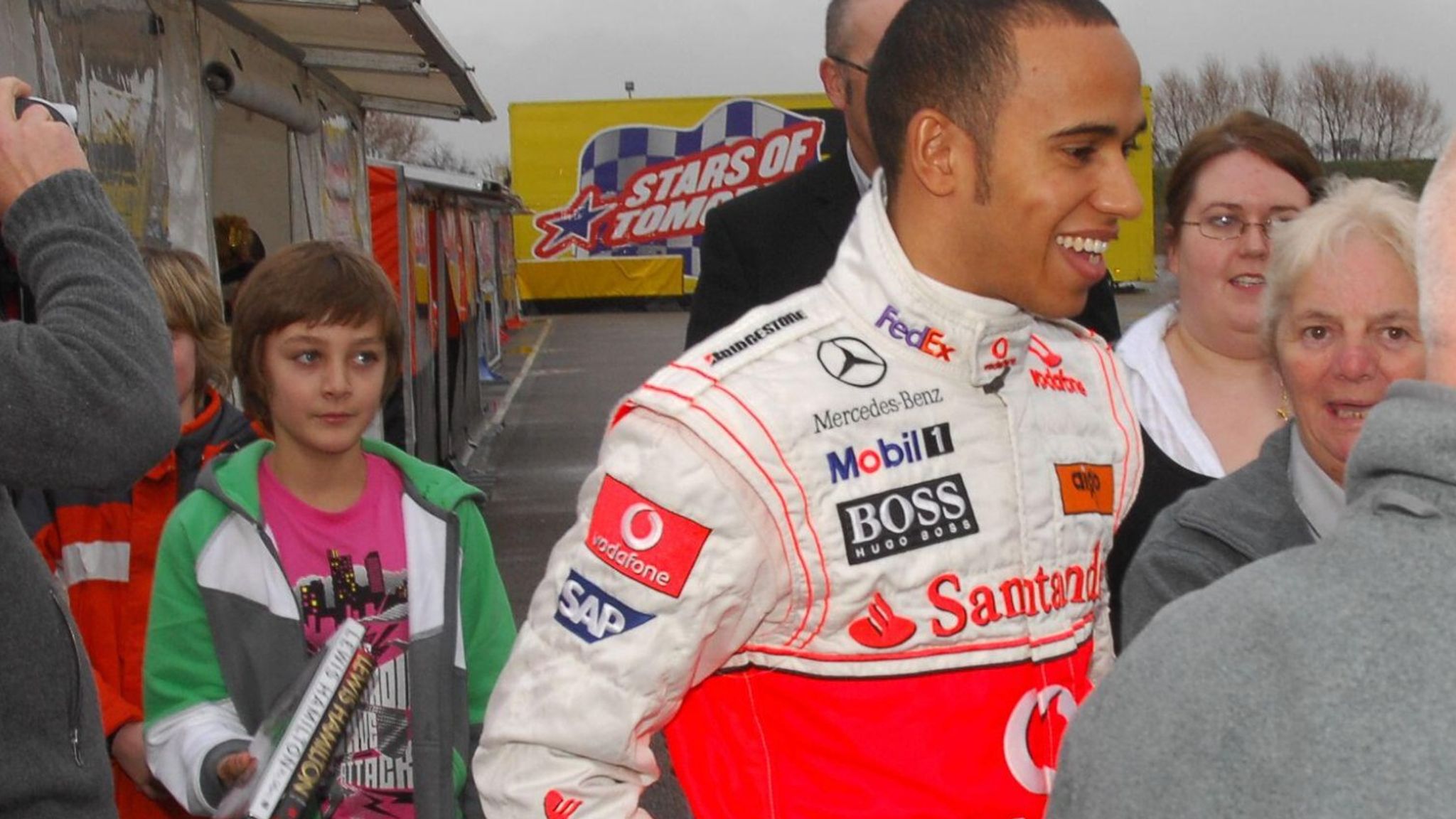 Young George Russel standing behind Lewis Hamilton